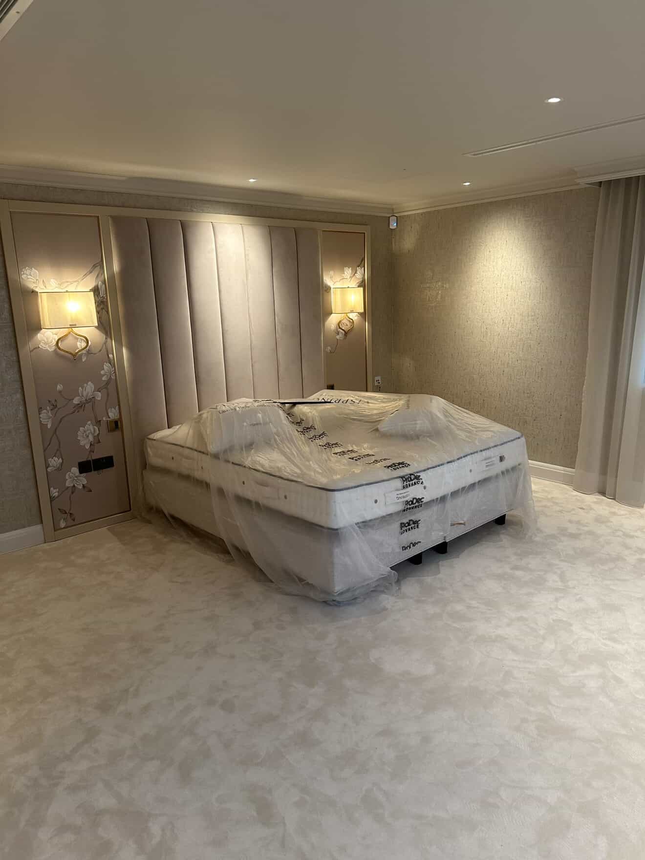 Bedroom with wall sconces, recessed downlights and padded headboard lighting installation