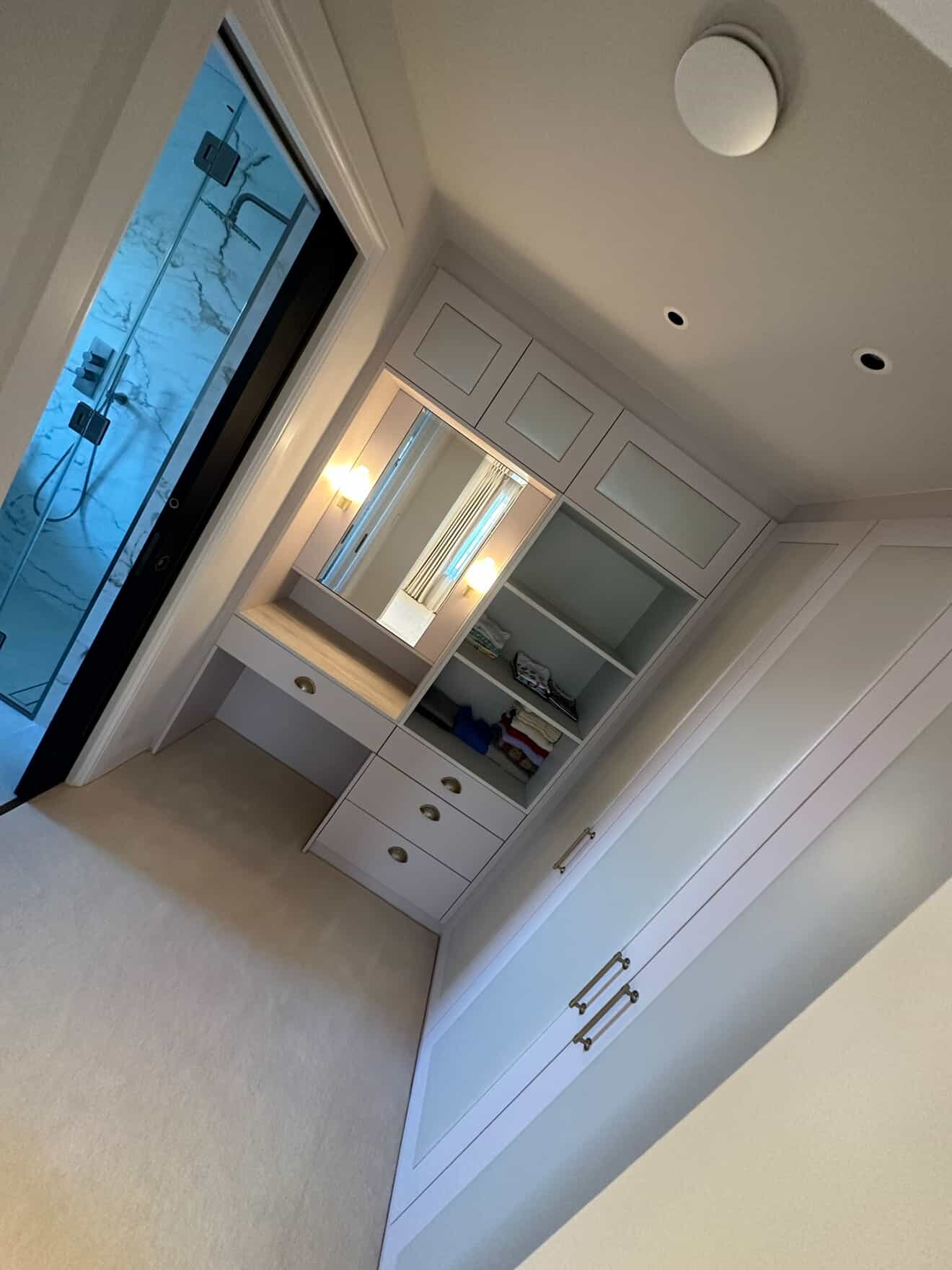 Dressing room with illuminated vanity mirror and recessed smart downlights