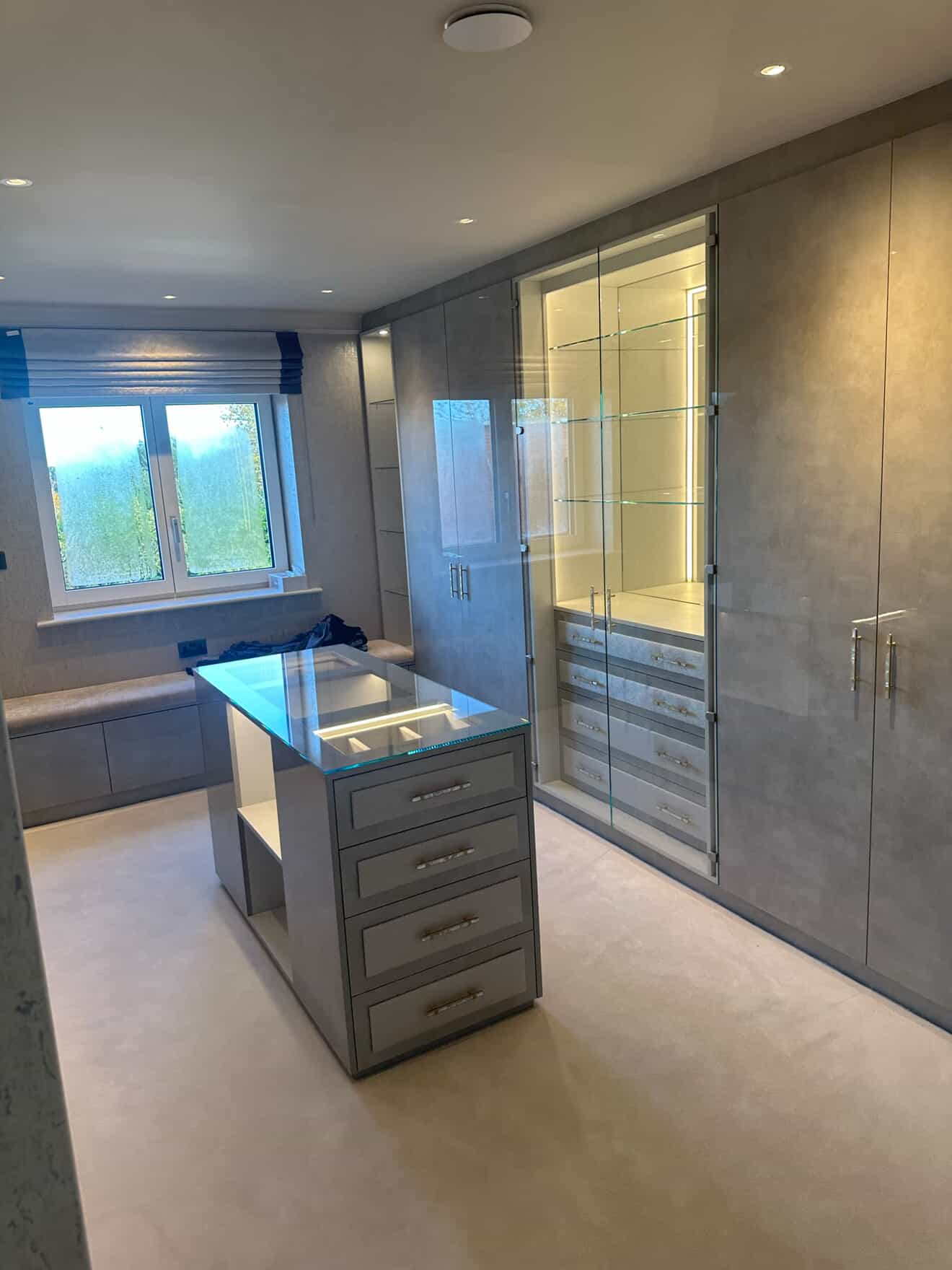 Walk-in wardrobe with LED-lit glass display cabinet and smart lighting control